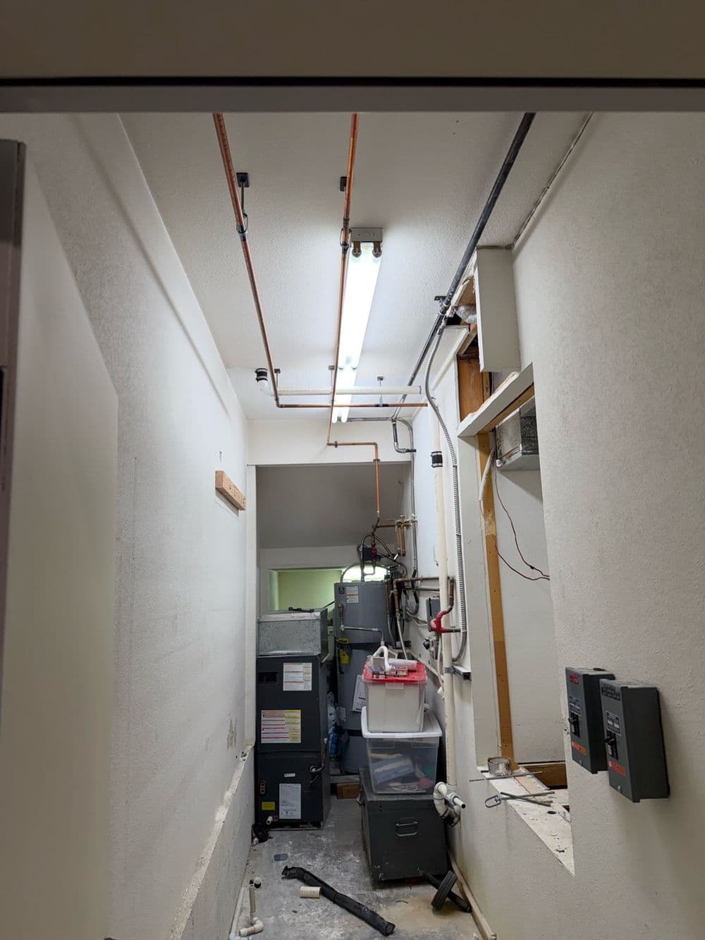 New copper water lines run along a commercial hallway ceiling