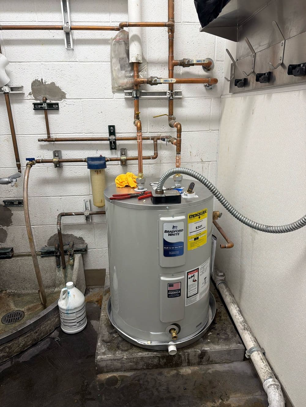 Electric tank water heater in a block-wall utility room