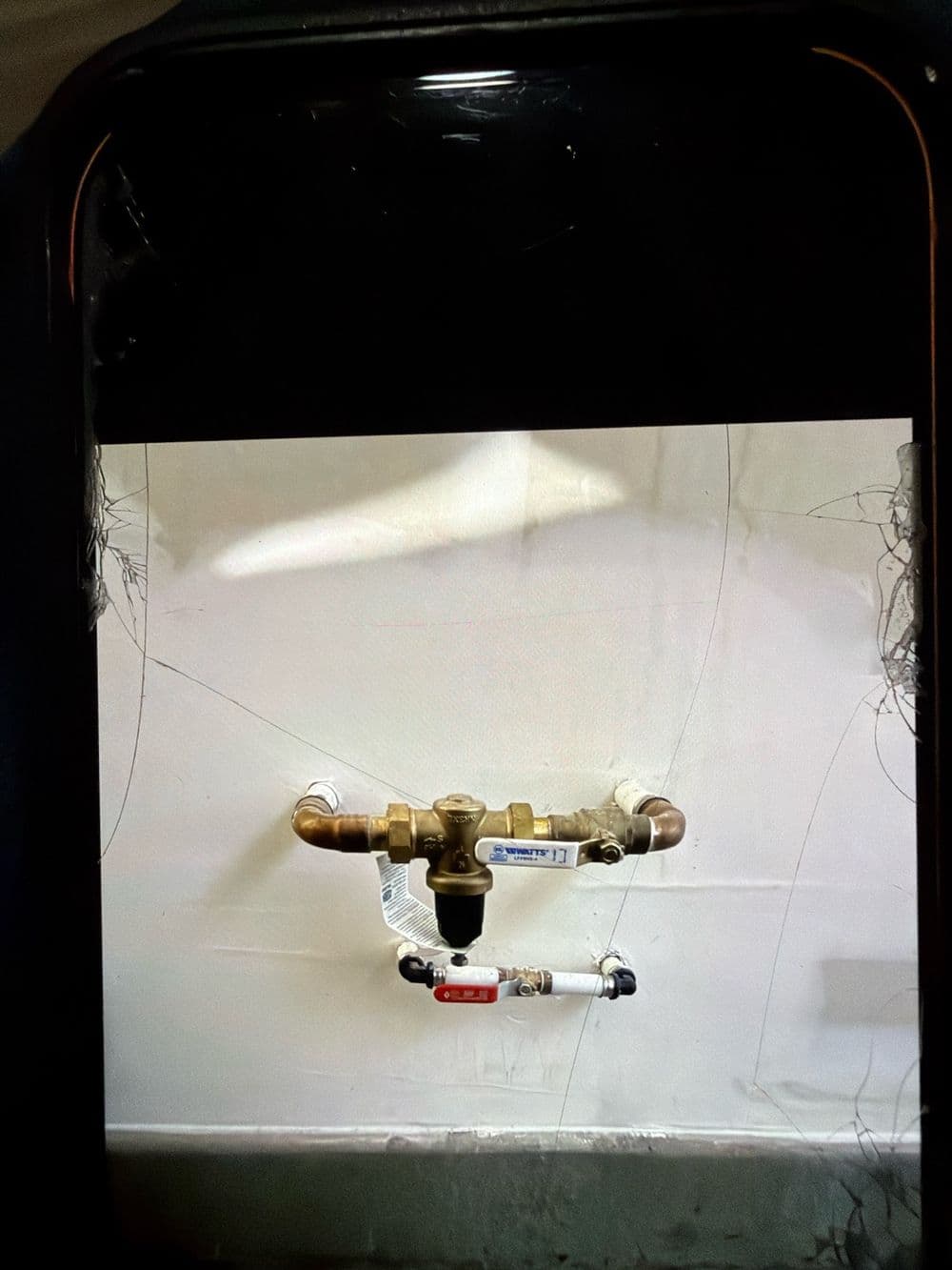 Brass pressure-reducing valve and piping on an exterior wall
