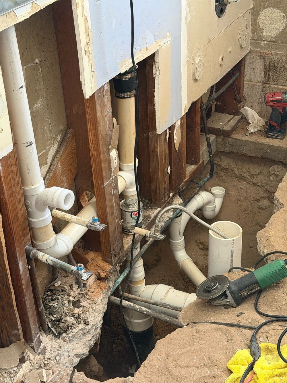 New PVC drain lines laid in a trench cut through a slab